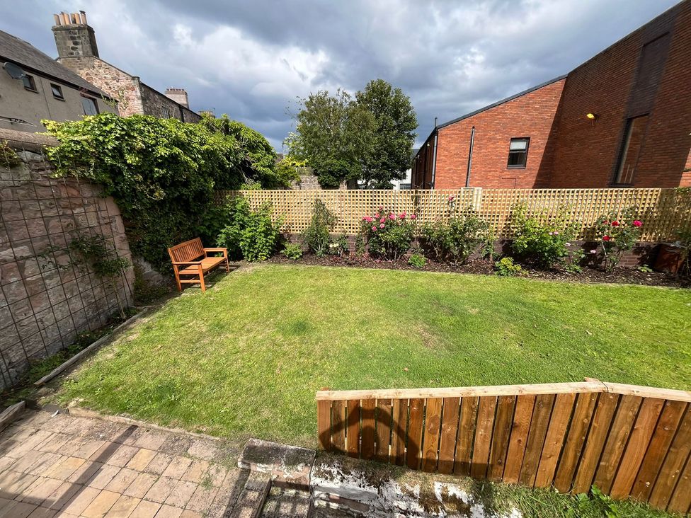 A garden with a bench and flower beds at Secret Garden in Berwick-Upon-Tweed