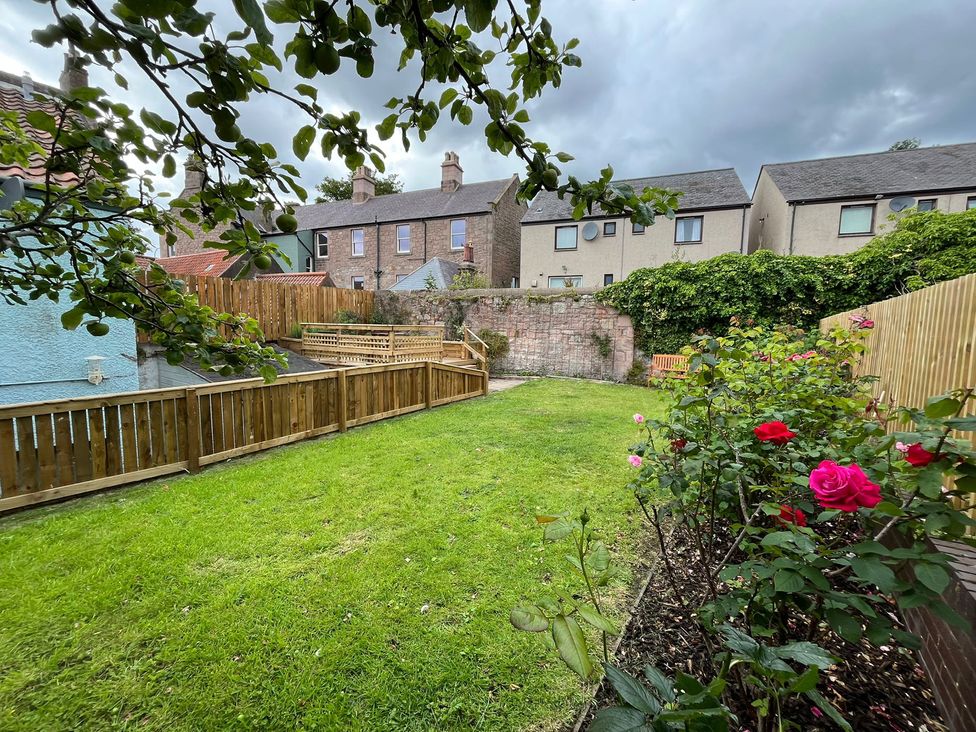 A garden with grass and roses at Secret Garden in Berwick-Upon-Tweed