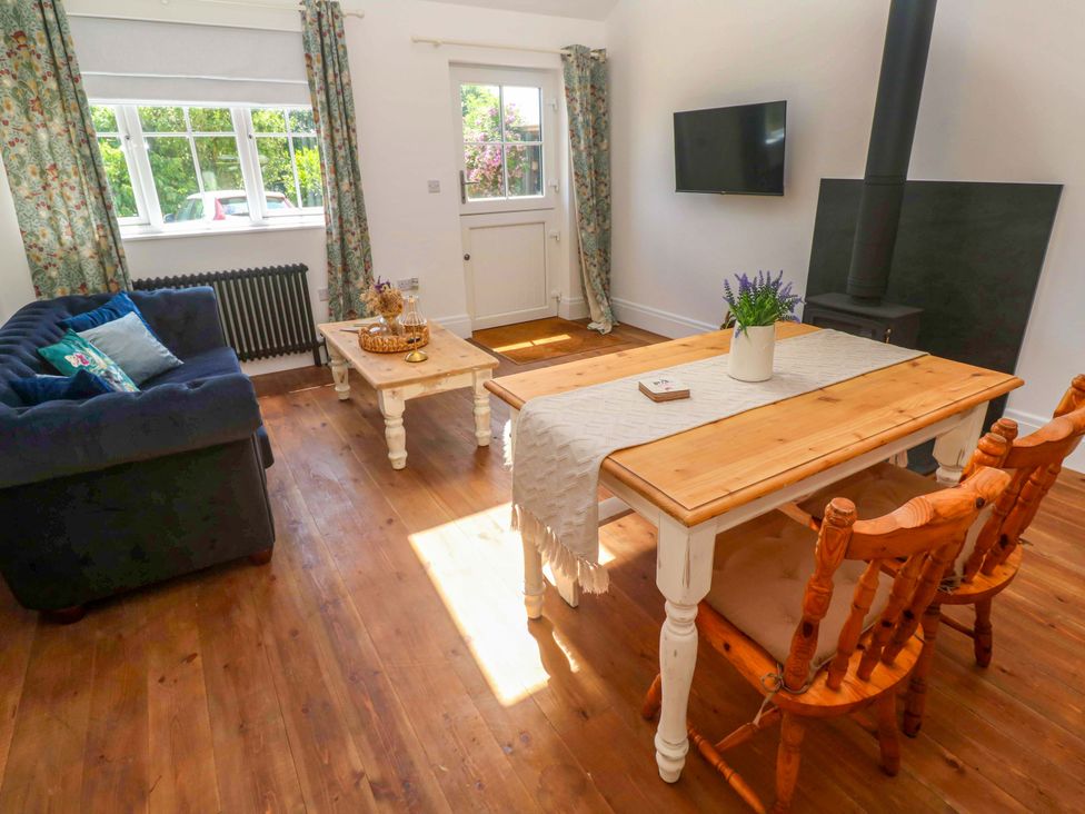A living room with a sofa table and chairs at Lavender Cottage