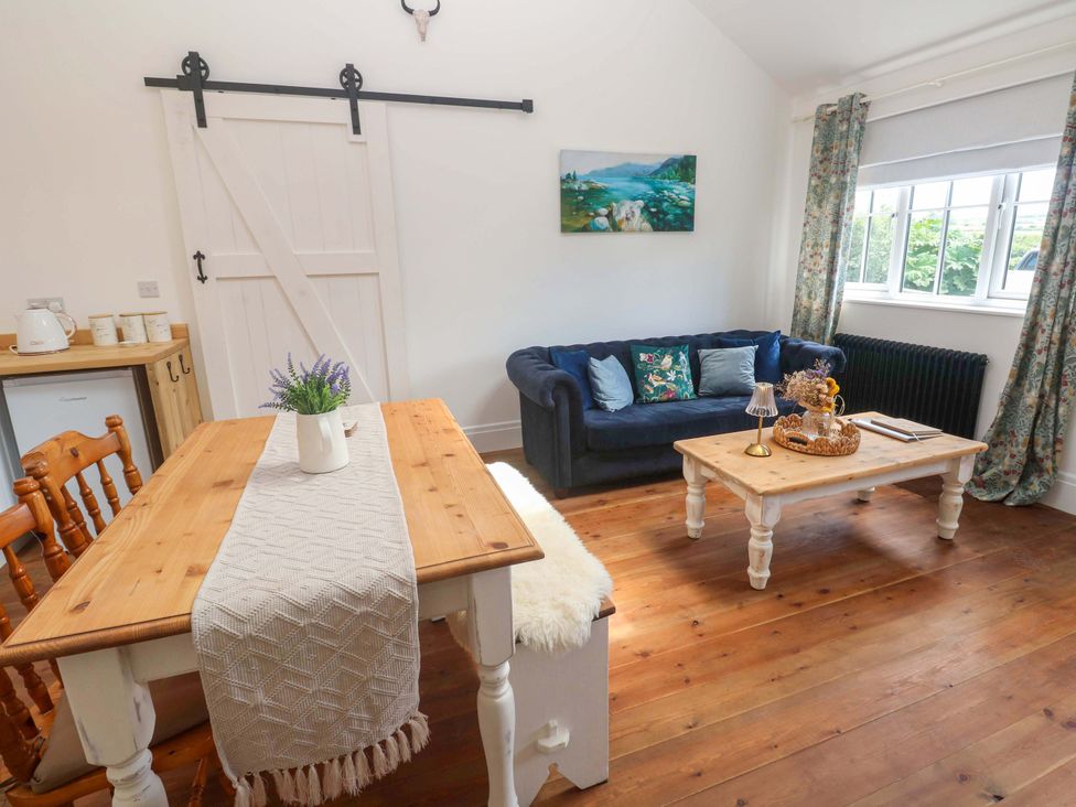 A living room with a table and chairs at Lavender Cottage 