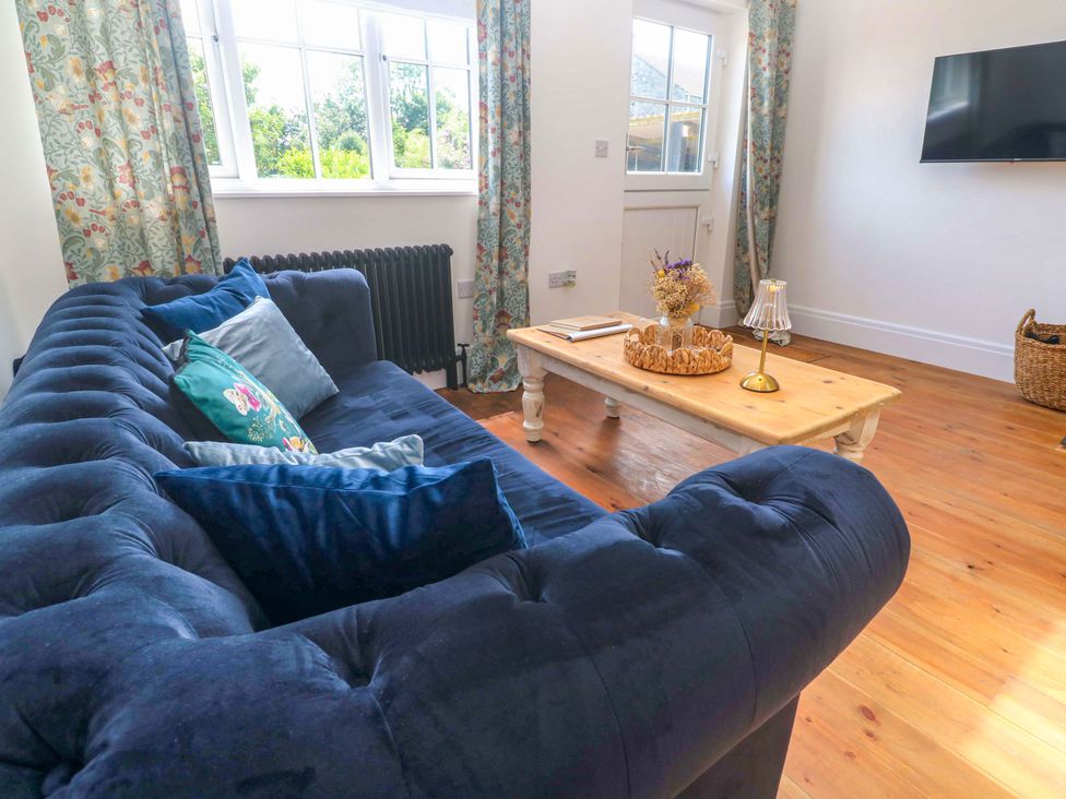 A living room with a sofa and coffee table at Lavender Cottage