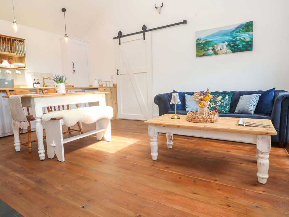A living room with a sofa table and dining area at Lavender Cottage