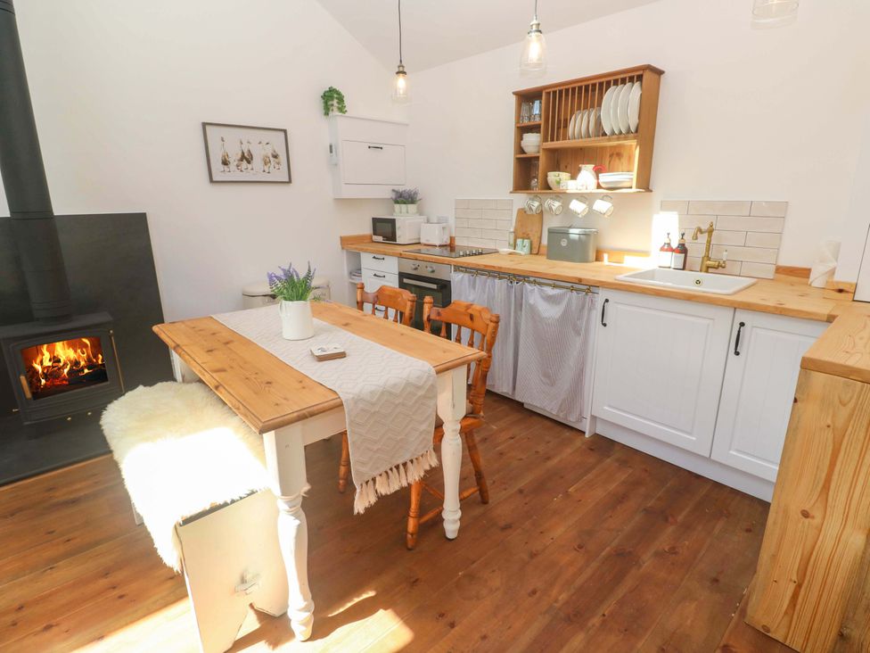 A kitchen with a wooden table and chairs at Lavender Cottage