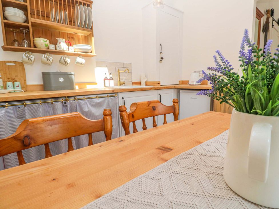 A kitchen with wooden table and chairs at Lavender Cottage