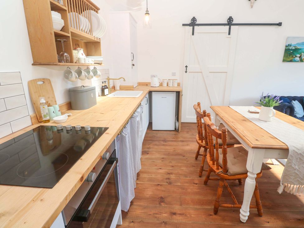 A kitchen with wooden countertop and dining table at Lavender Cottage