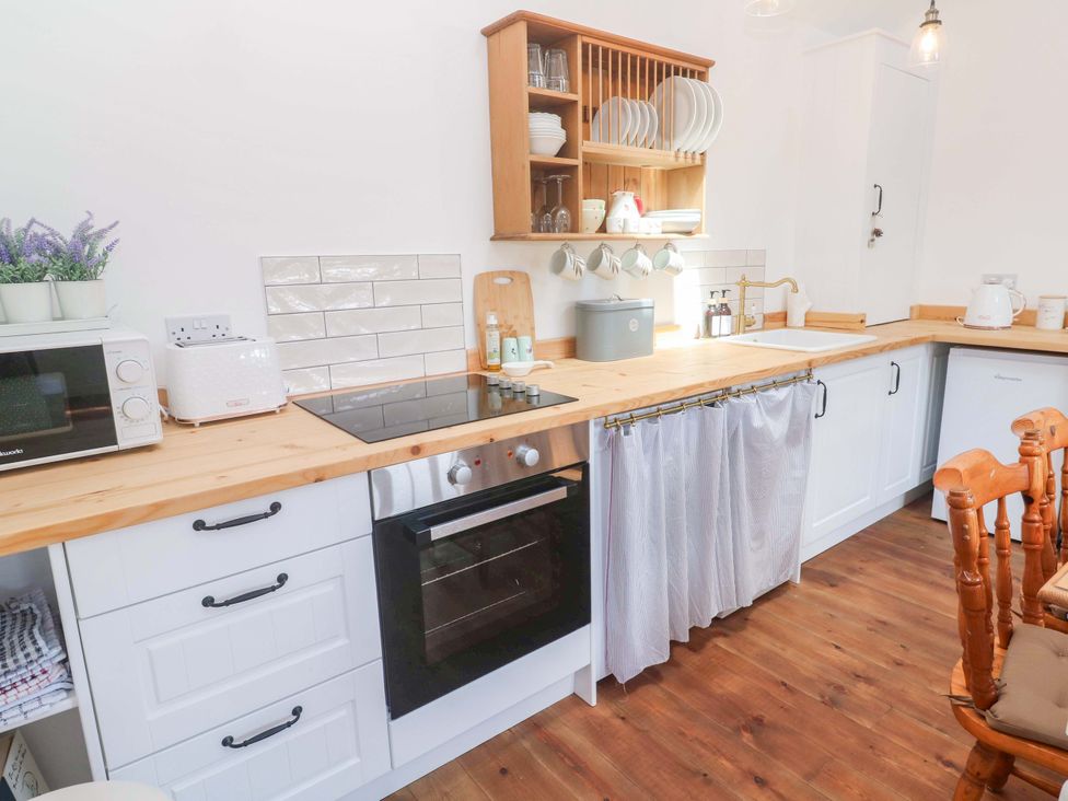 A kitchen with appliances and wooden countertops at Lavender Cottage