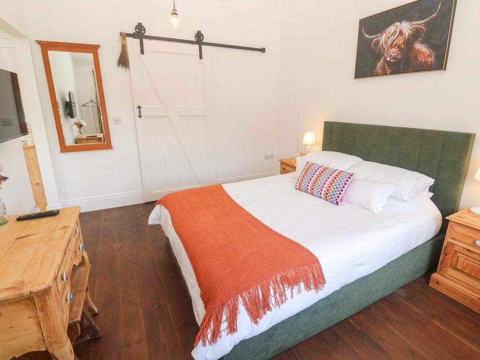 A bedroom with a bed and bedside tables at Lavender Cottage