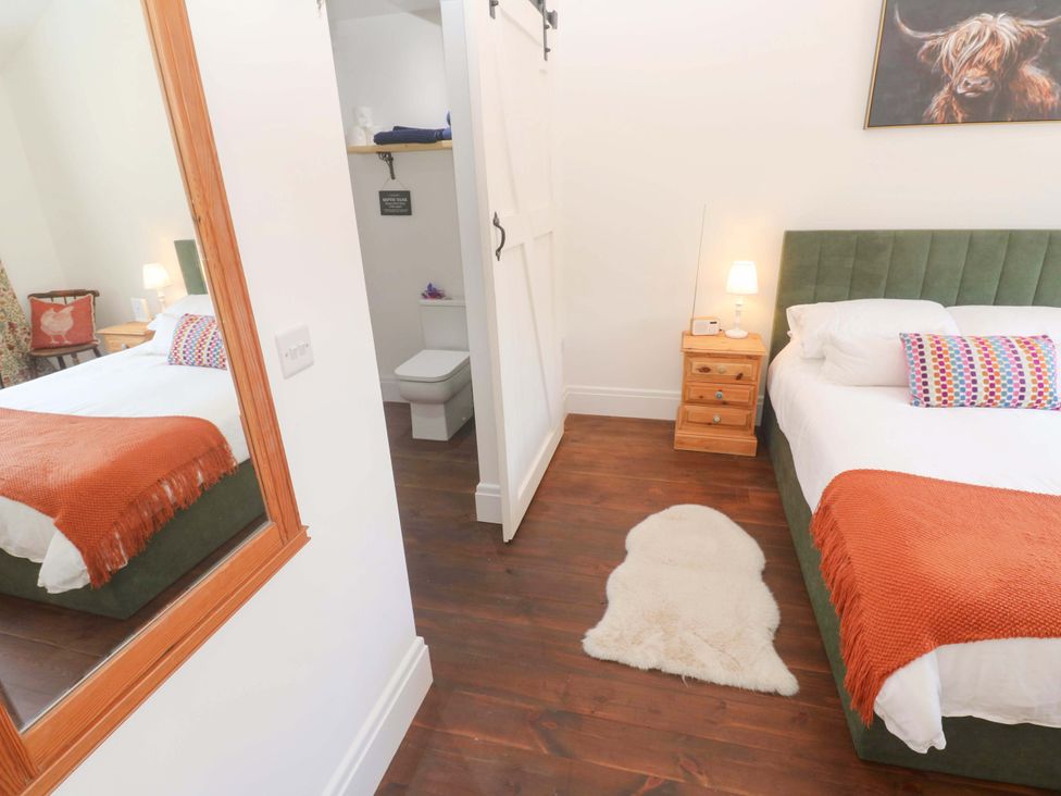 A bedroom with a bed and nightstand at Lavender Cottage
