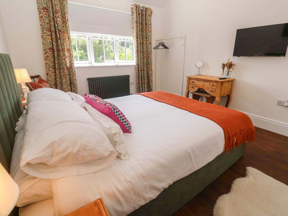 A bedroom with a bed and curtains at Lavender Cottage 