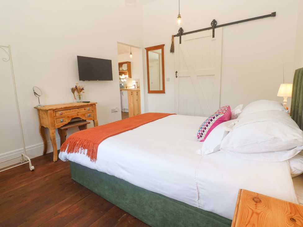 A bedroom with a bed and a nightstand at Lavender Cottage