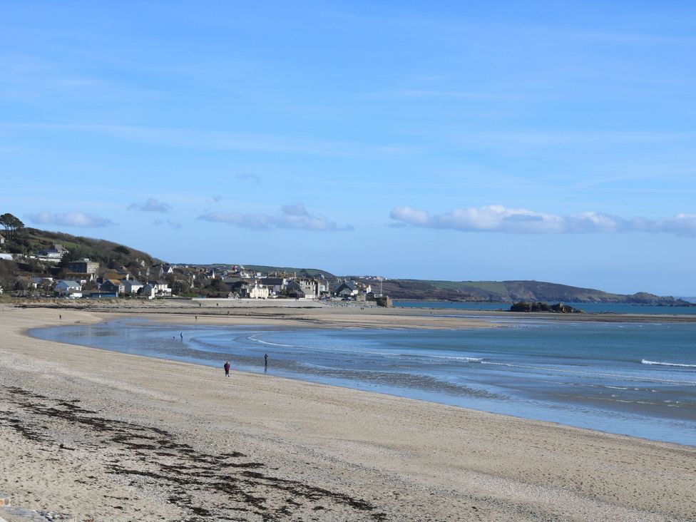 A beach with water and houses in the background at Lavender Cottage