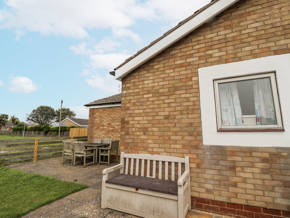 An outdoor seating area with a bench and table at 51 Longstone Park