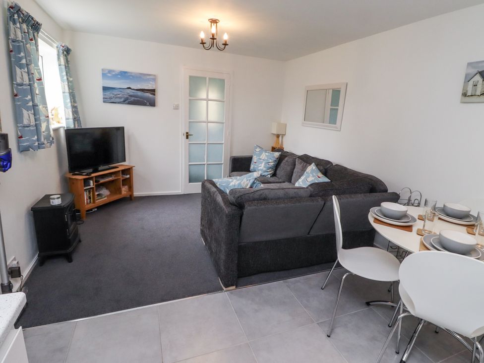 A living room with a sofa and dining table at 51 Longstone Park
