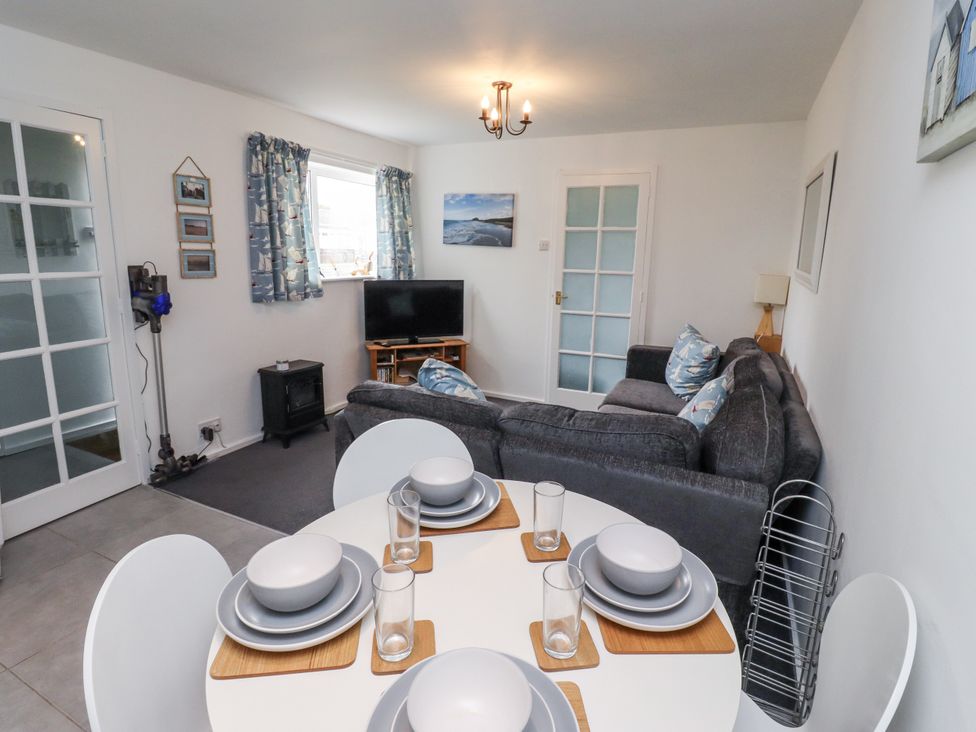 A living room with a sofa and dining table at 51 Longstone Park