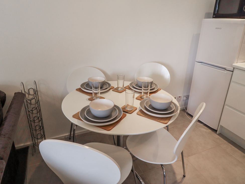 A dining table with dishes and chairs at 51 Longstone Park