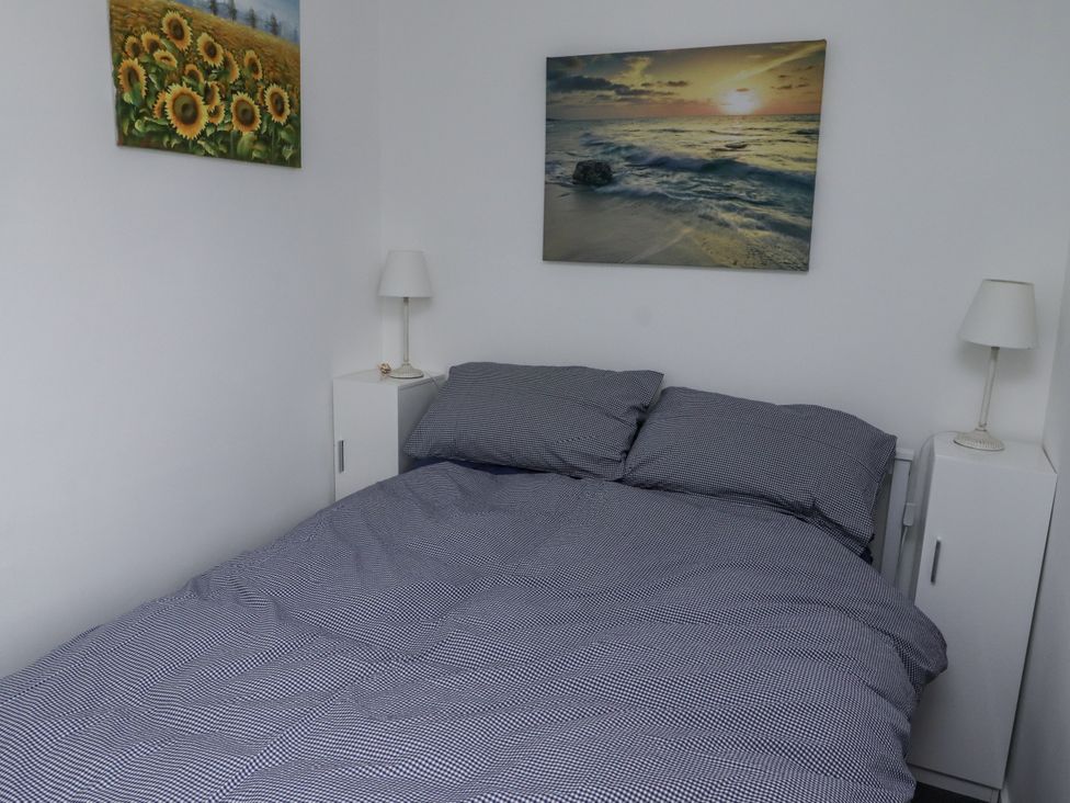 A bedroom with a bed and bedside tables at 51 Longstone Park