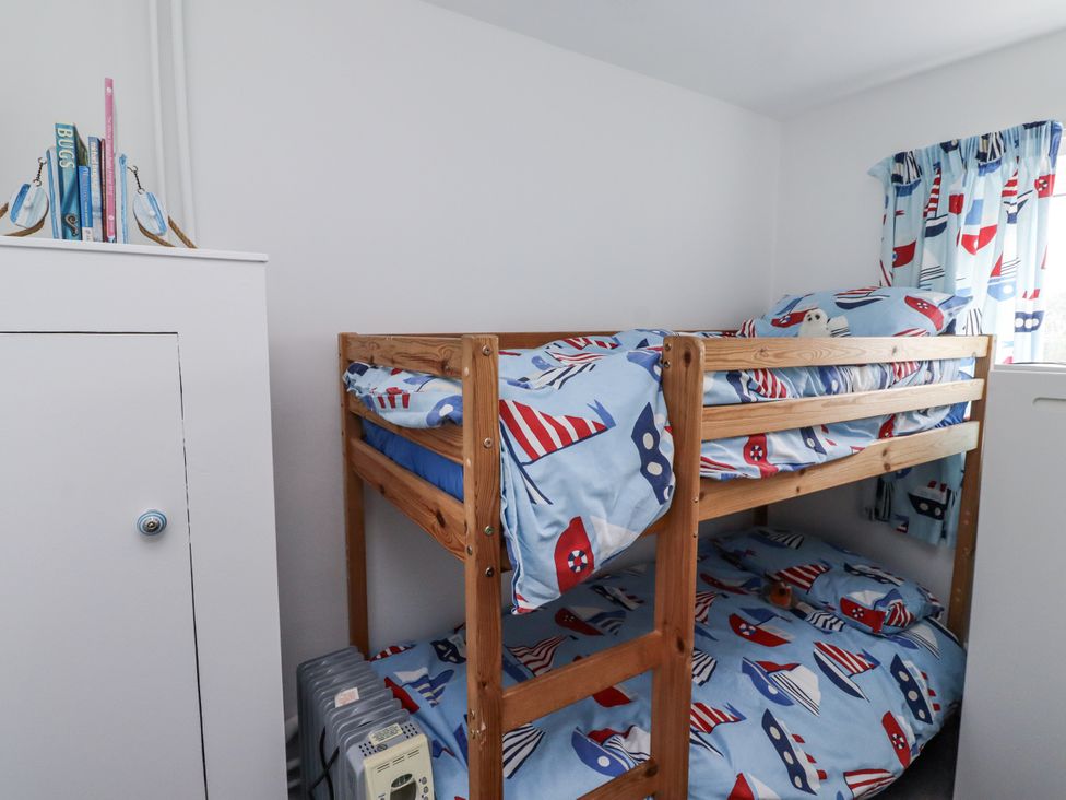 A bedroom with a bunk bed and bookshelf at 51 Longstone Park