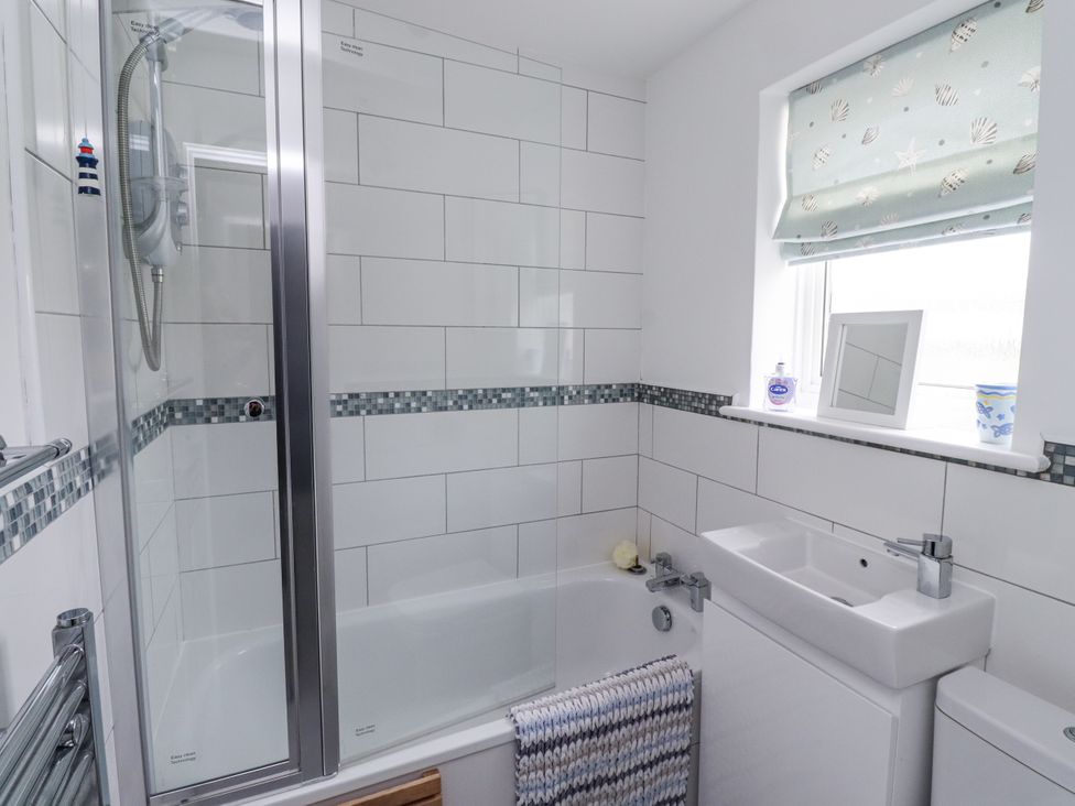 A bathroom with a shower and bathtub at 51 Longstone Park