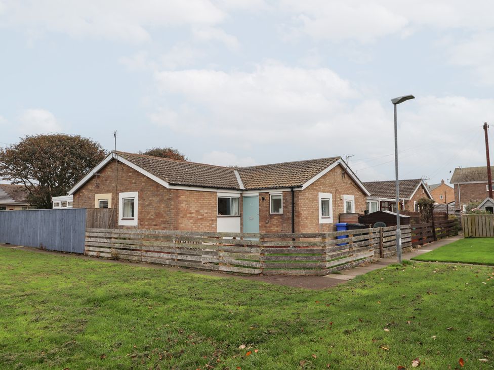 A house with a fence and grass area at 51 Longstone Park, Beadnell