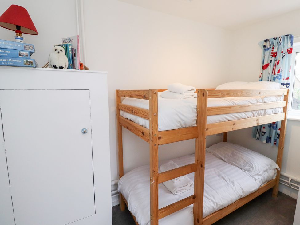 A bedroom with a bunk bed and a lamp at 51 Longstone Park in Beadnell