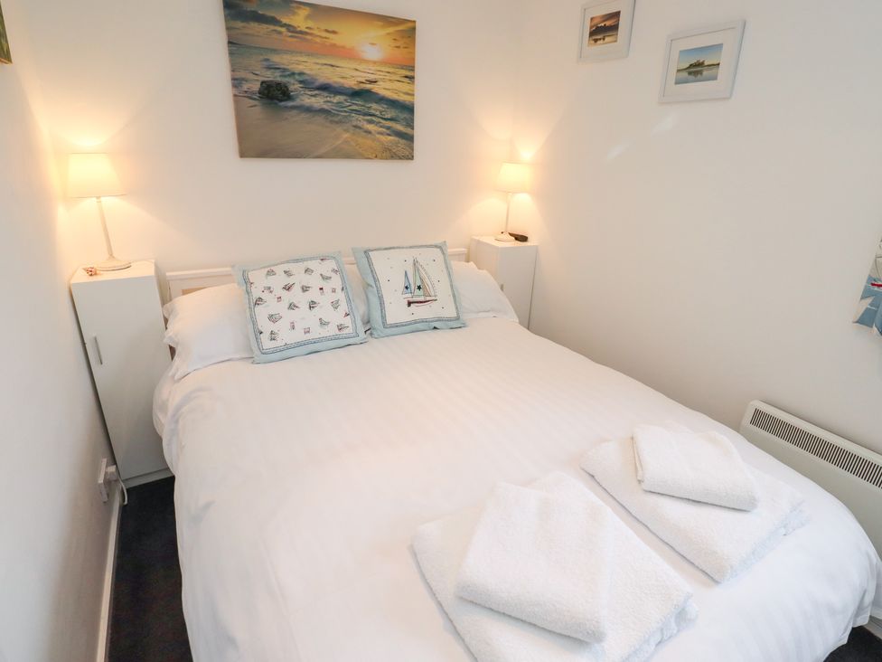 A bedroom with a bed and bedside tables at 51 Longstone Park Beadnell
