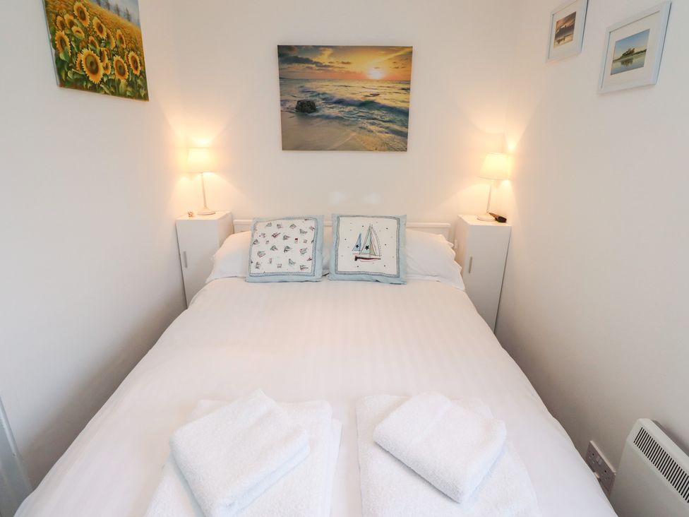 A bedroom with a bed and wall decorations at 51 Longstone Park Beadnell