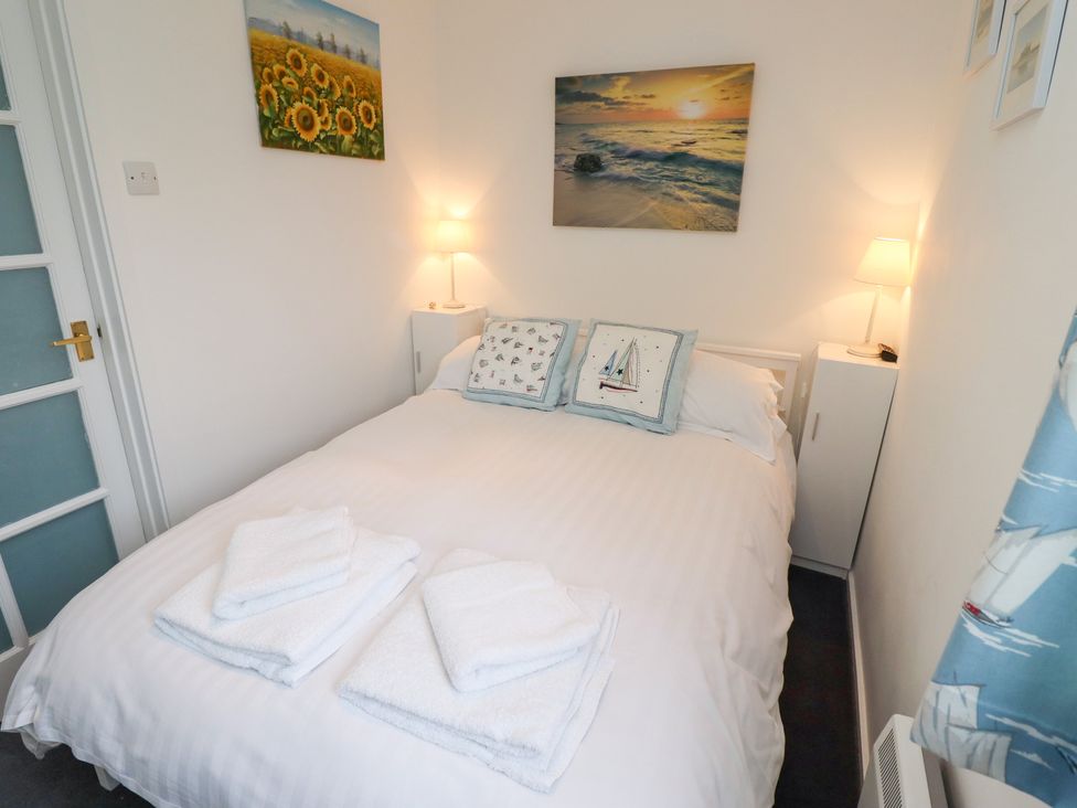 A bedroom with a bed and artwork at 51 Longstone Park Beadnell