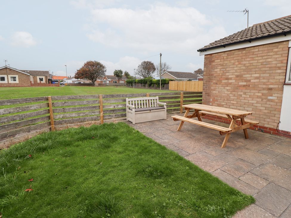 A garden with a picnic table and bench at 51 Longstone Park Beadnell