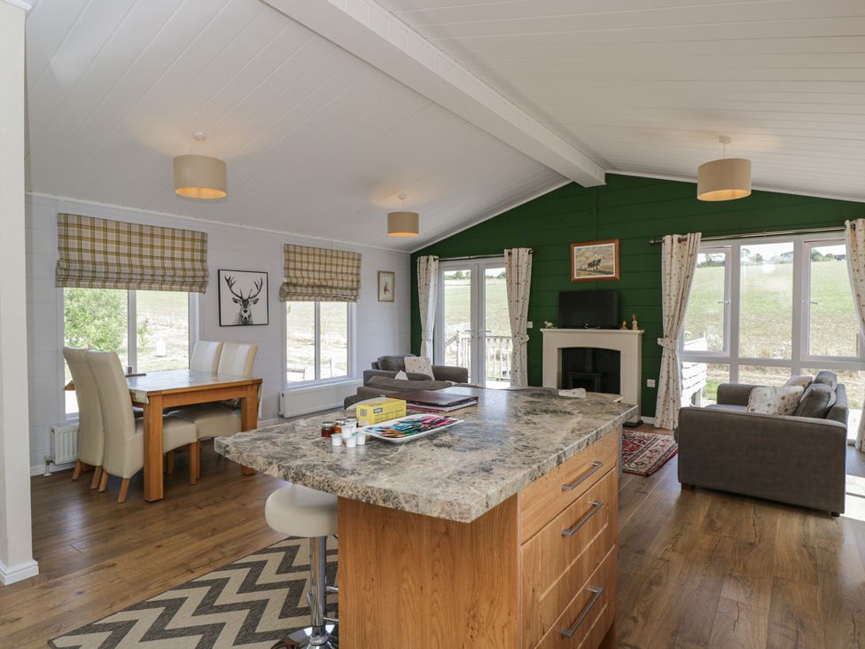 A living room with a kitchen island and dining area at The Buckland in Pentridge near Sixpenny Handley