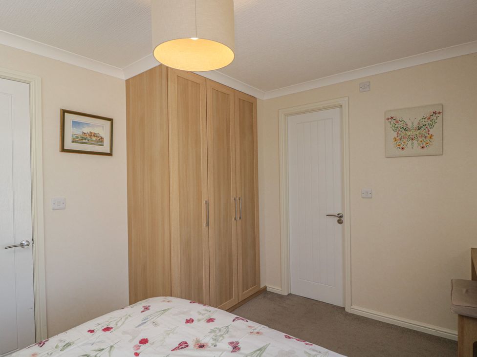 A bedroom with a wardrobe and door at The Buckland in Pentridge near Sixpenny Handley
