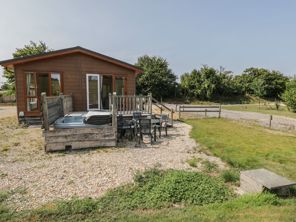 An outdoor area with a deck and hot tub at The Buckland in Pentridge near Sixpenny Handley