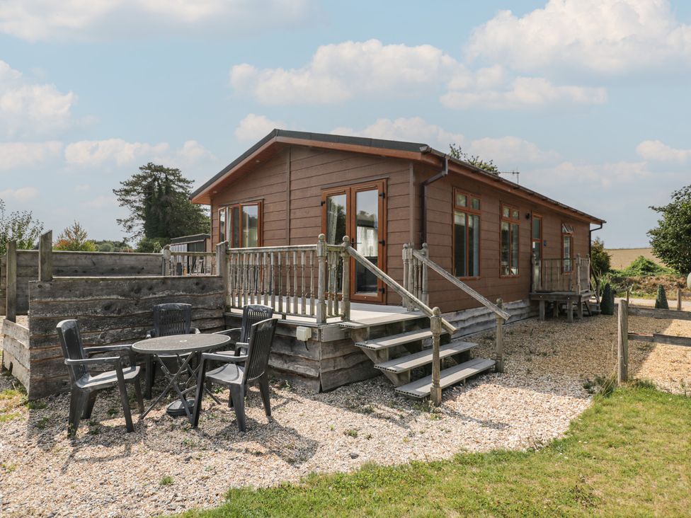 A cabin with a deck and seating area at The Buckland in Pentridge near Sixpenny Handley