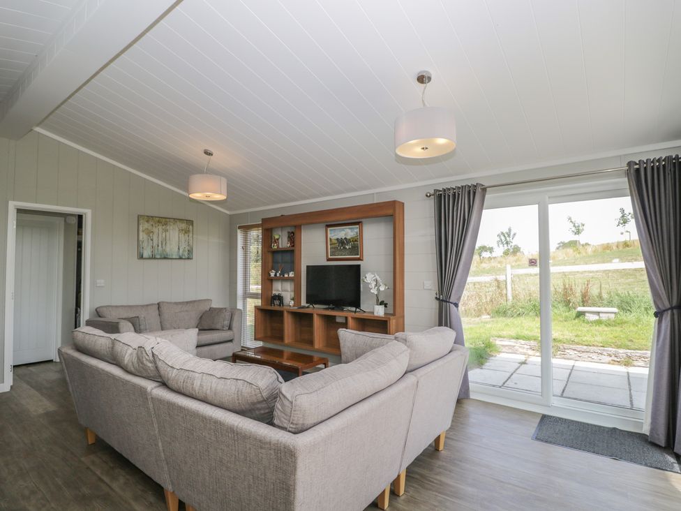 A living room with a sofa and TV unit at Whitey Top Country Lodge Pentridge near Sixpenny Handley