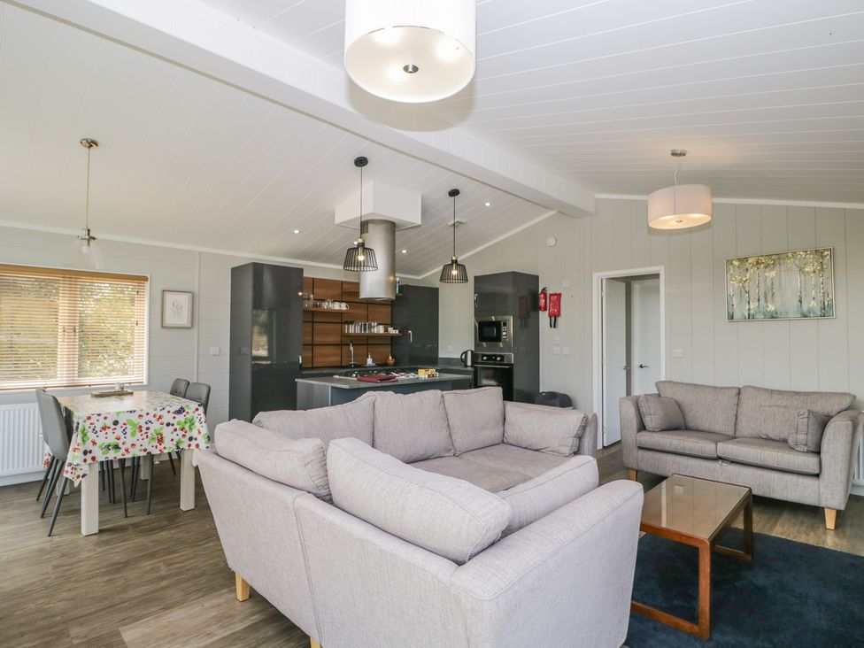 A living room and kitchen setup with sofas and dining table at Whitey Top Country Lodge in Pentridge near Sixpenny Handley
