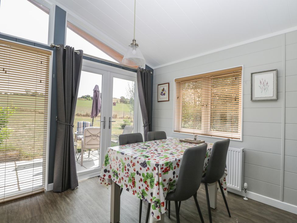 A dining room with a table and chairs at Whitey Top Country Lodge in Pentridge near Sixpenny Handley