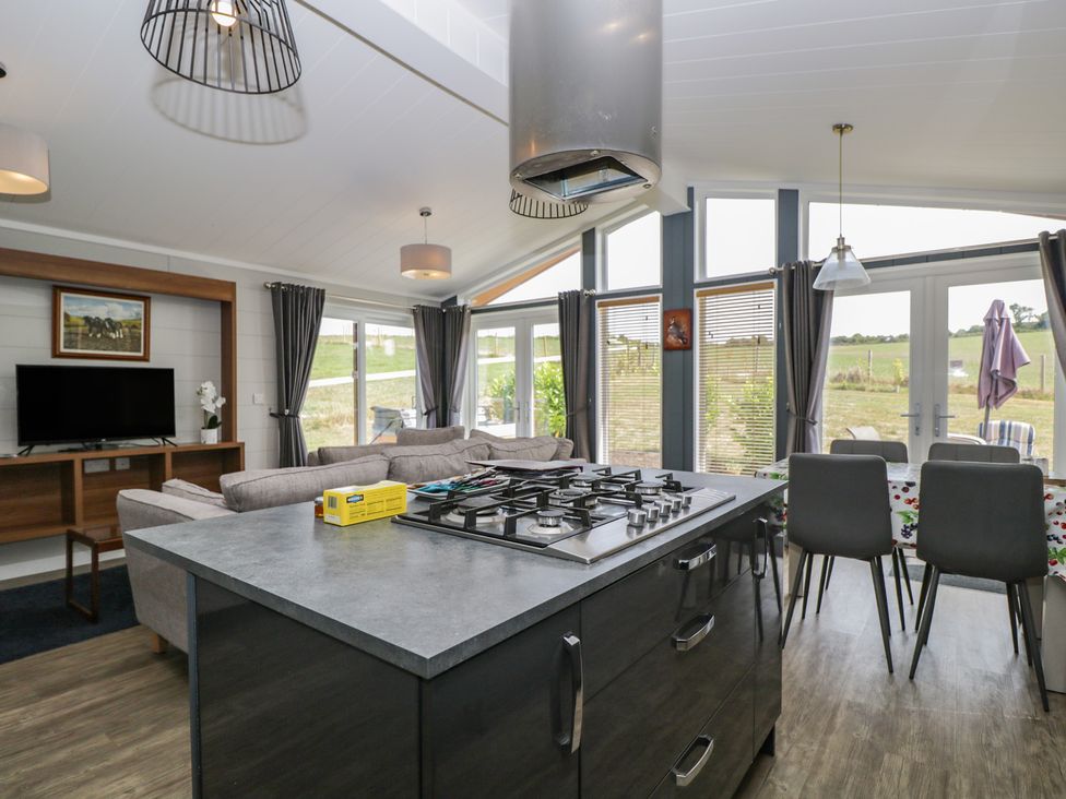 A kitchen with a gas stove and dining table at Whitey Top Country Lodge in Pentridge near Sixpenny Handley