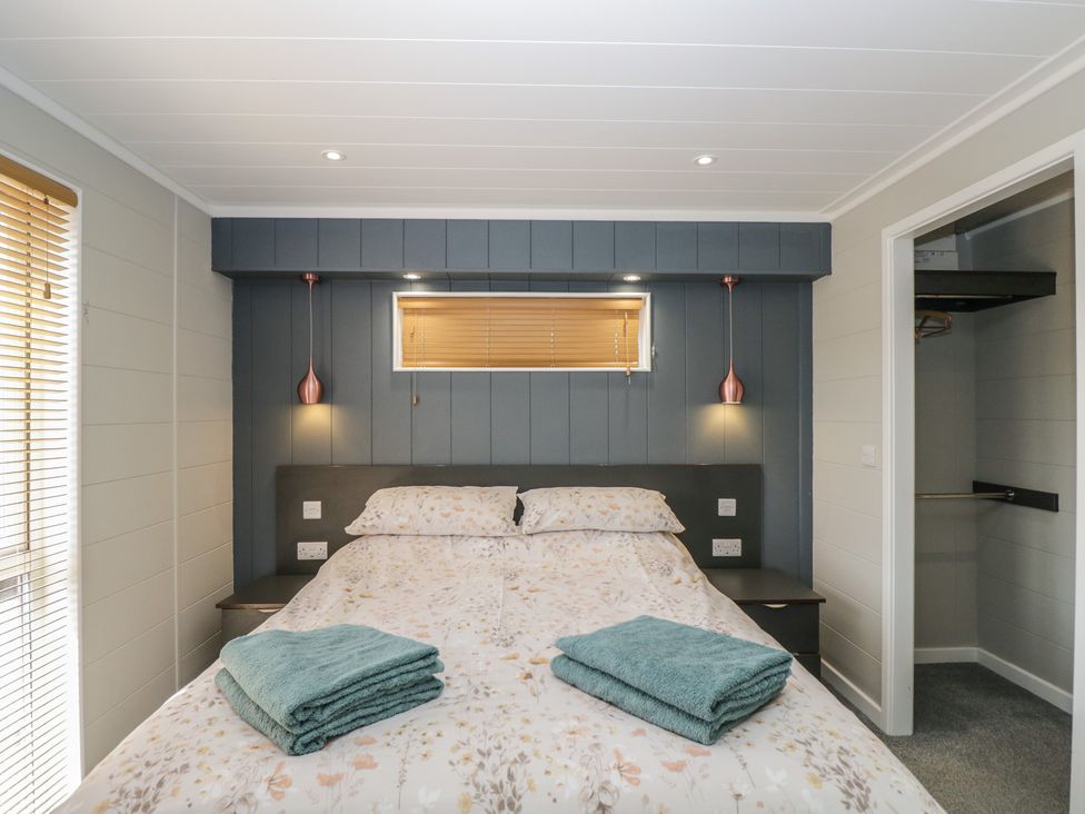 A bedroom with a bed and towels at Whitey Top Country Lodge Pentridge near Sixpenny Handley