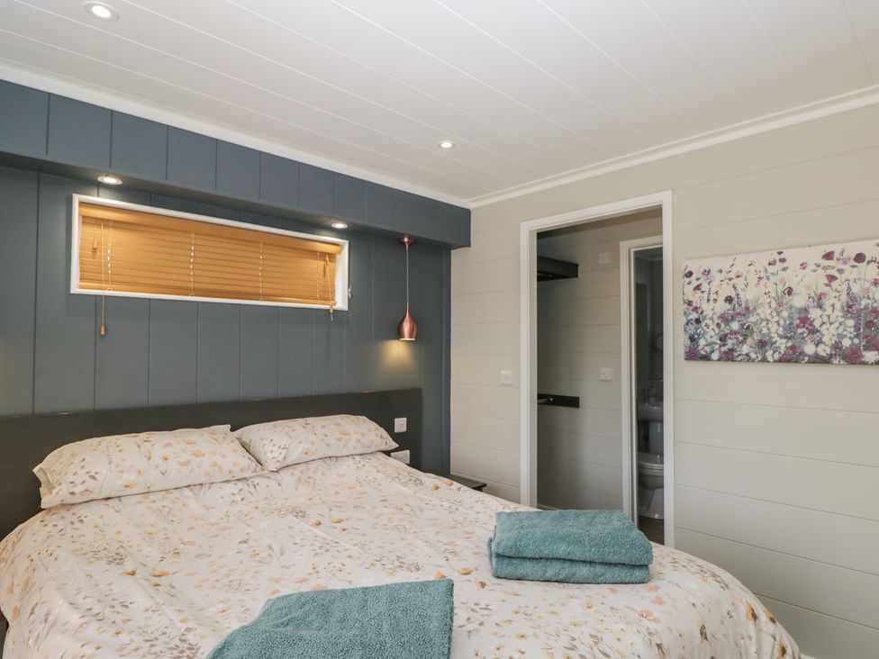 A bedroom with a bed and towels at Whitey Top Country Lodge in Pentridge near Sixpenny Handley