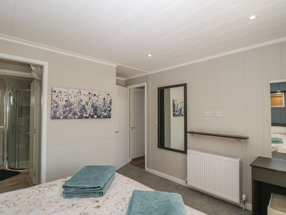 A bedroom with a bed and towels at Whitey Top Country Lodge in Pentridge near Sixpenny Handley