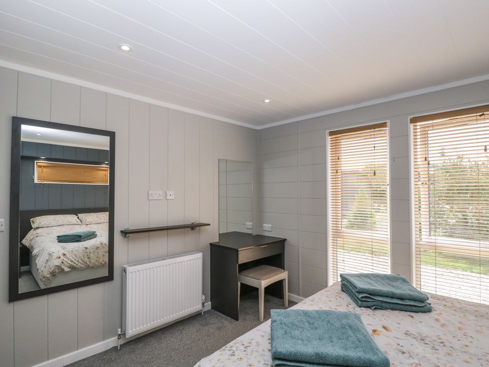 A bedroom with a bed and desk at Whitey Top Country Lodge in Pentridge near Sixpenny Handley