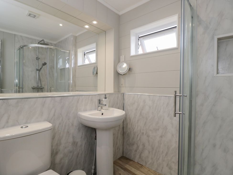 A bathroom with a shower, sink, and toilet at Whitey Top Country Lodge in Pentridge near Sixpenny Handley