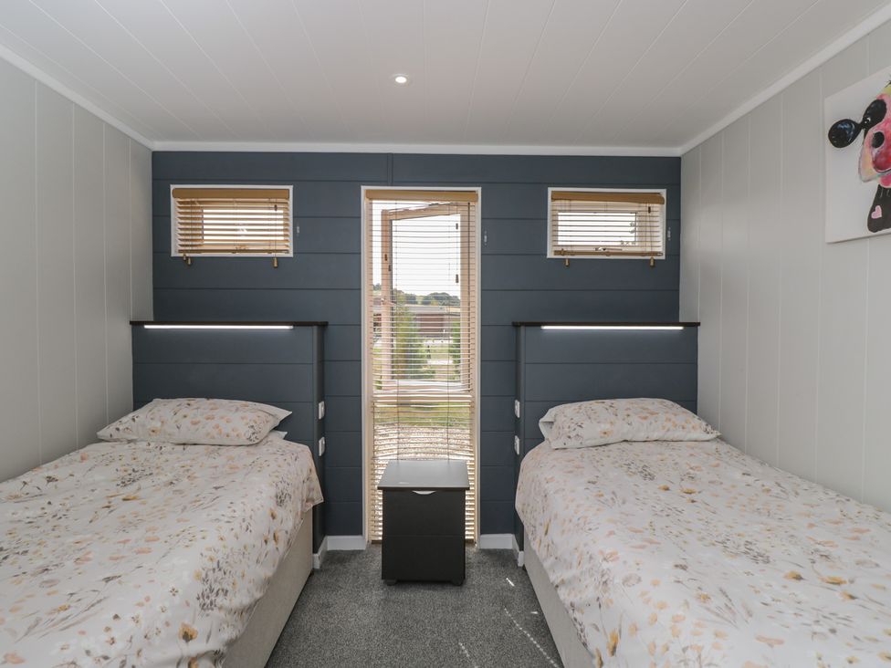 A bedroom with two beds and a window at Whitey Top Country Lodge Pentridge near Sixpenny Handley