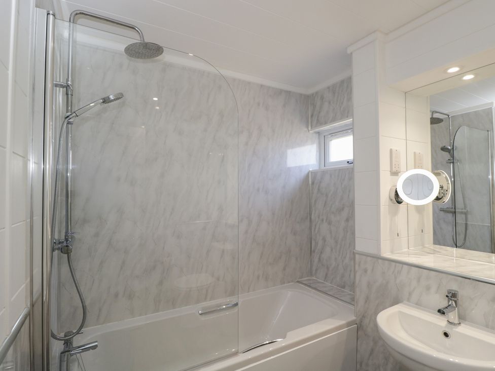 A bathroom with a bathtub and shower at Whitey Top Country Lodge, Pentridge near Sixpenny Handley