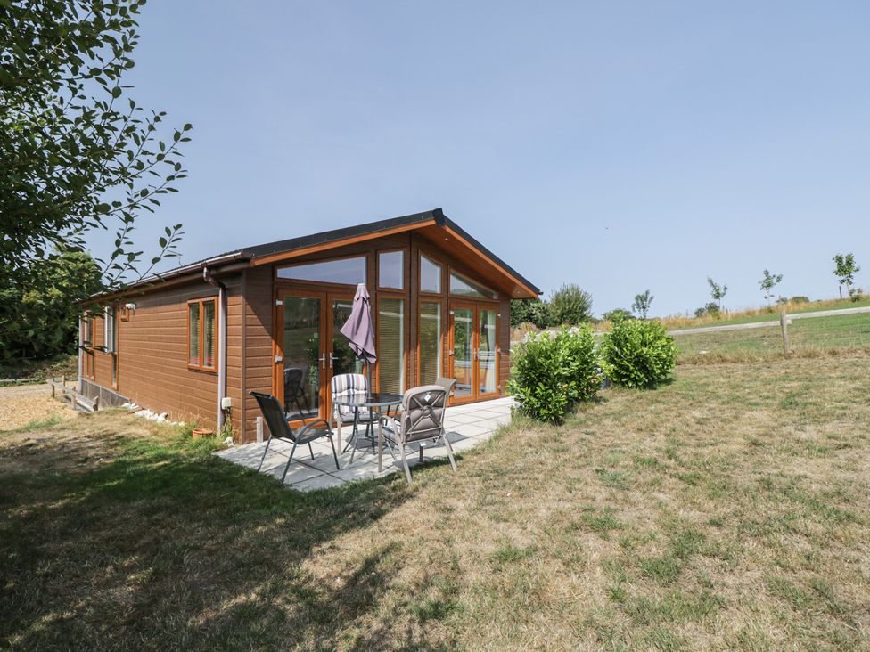 A lodge with table and chairs on a patio at Whitey Top Country Lodge in Pentridge near Sixpenny Handley