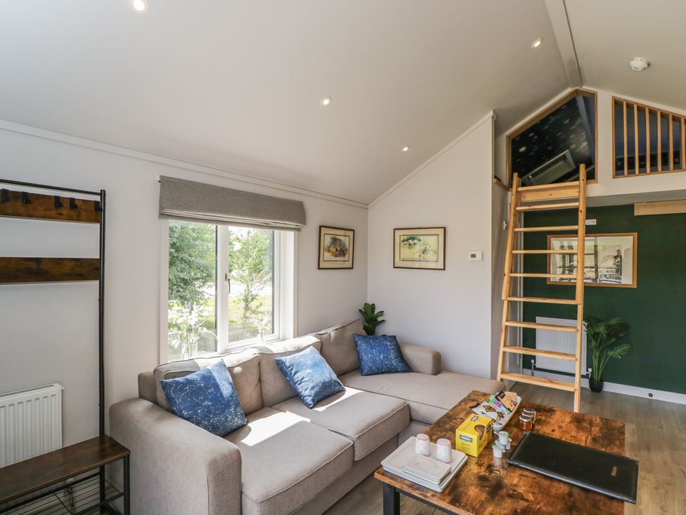 A living room with a sofa, table, and stairs at Cranborne Chase Stargazer, Pentridge near Sixpenny Handley