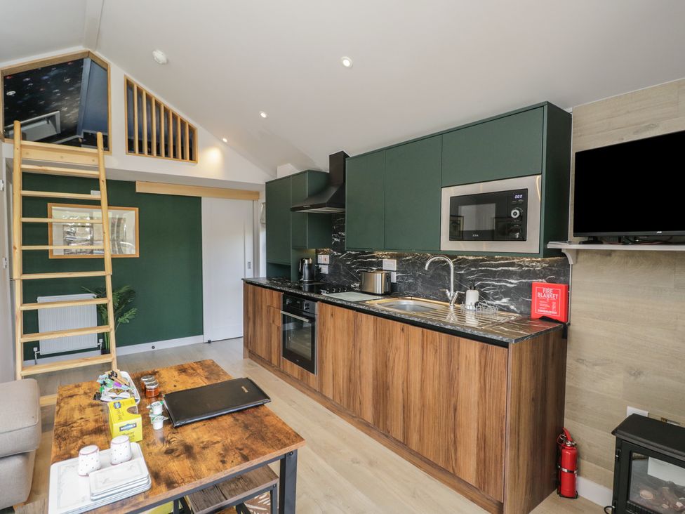 A kitchen with modern appliances and seating at Cranborne Chase Stargazer in Pentridge near Sixpenny Handley