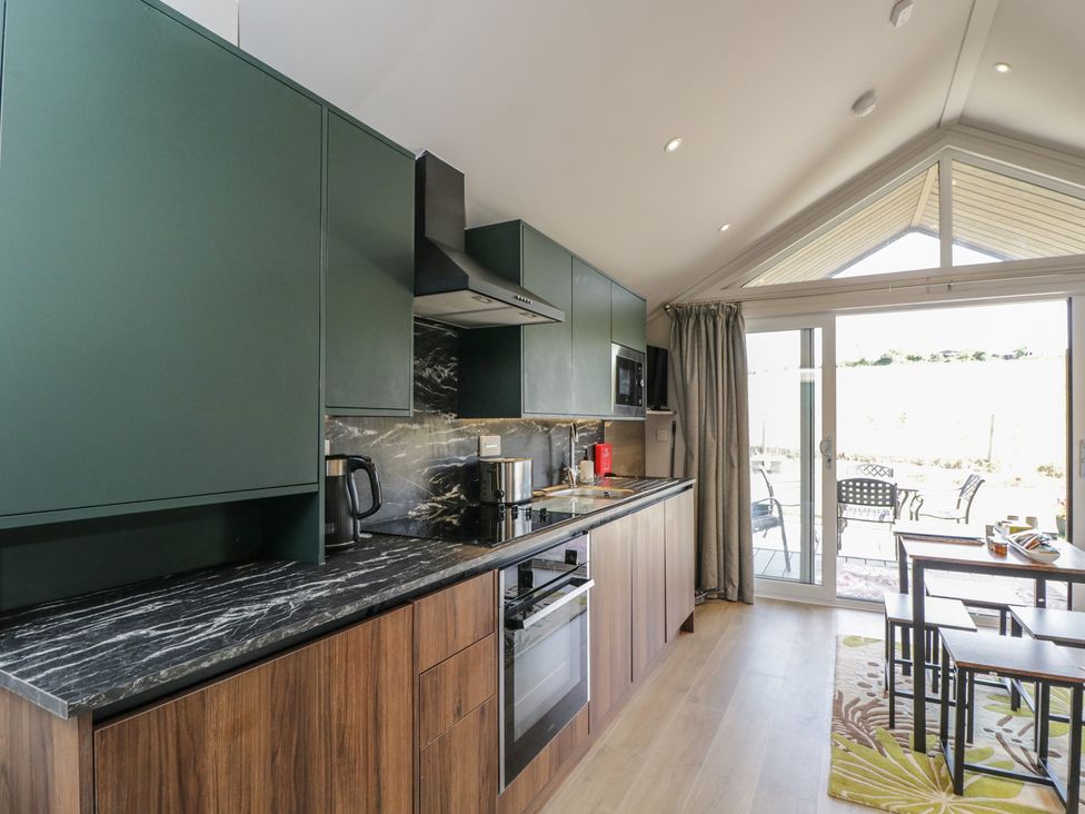 A kitchen with cabinets and a table at Cranborne Chase Stargazer in Pentridge near Sixpenny Handley