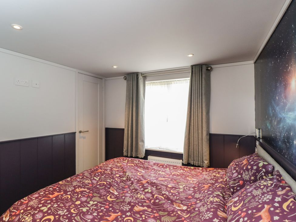 A bedroom with a bed and curtains at Cranborne Chase Stargazer in Pentridge near Sixpenny Handley