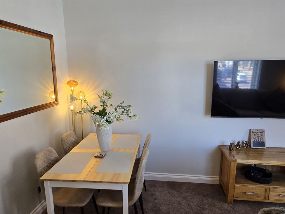 A dining room with a table and chairs at 2 Fern Avenue in Prestatyn