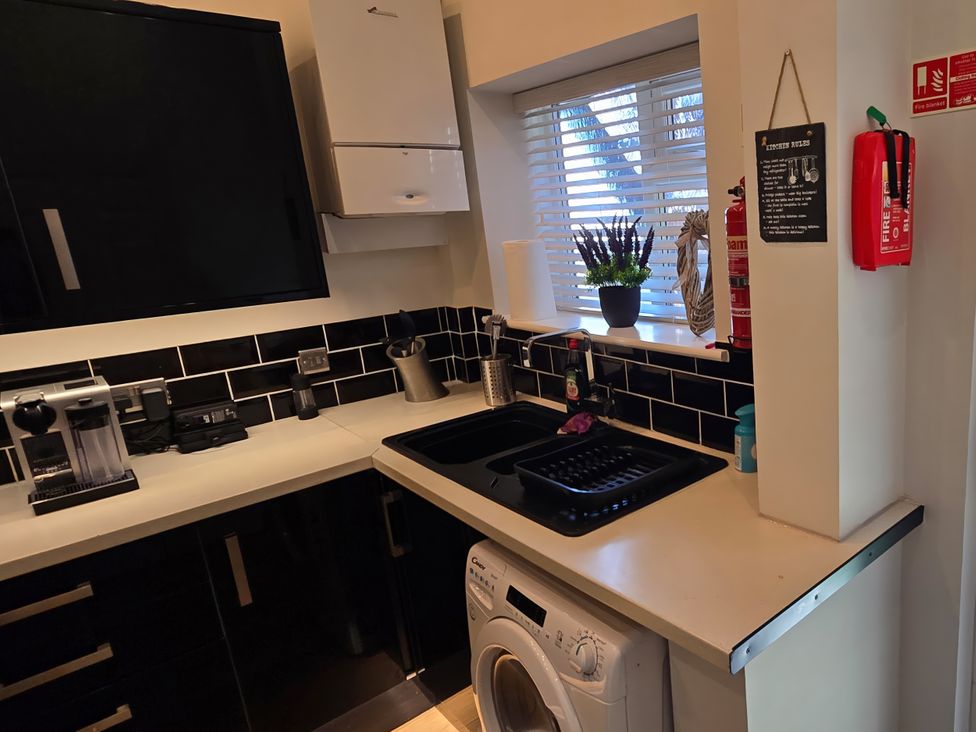 A kitchen with sink and washing machine at 2 Fern Avenue Prestatyn